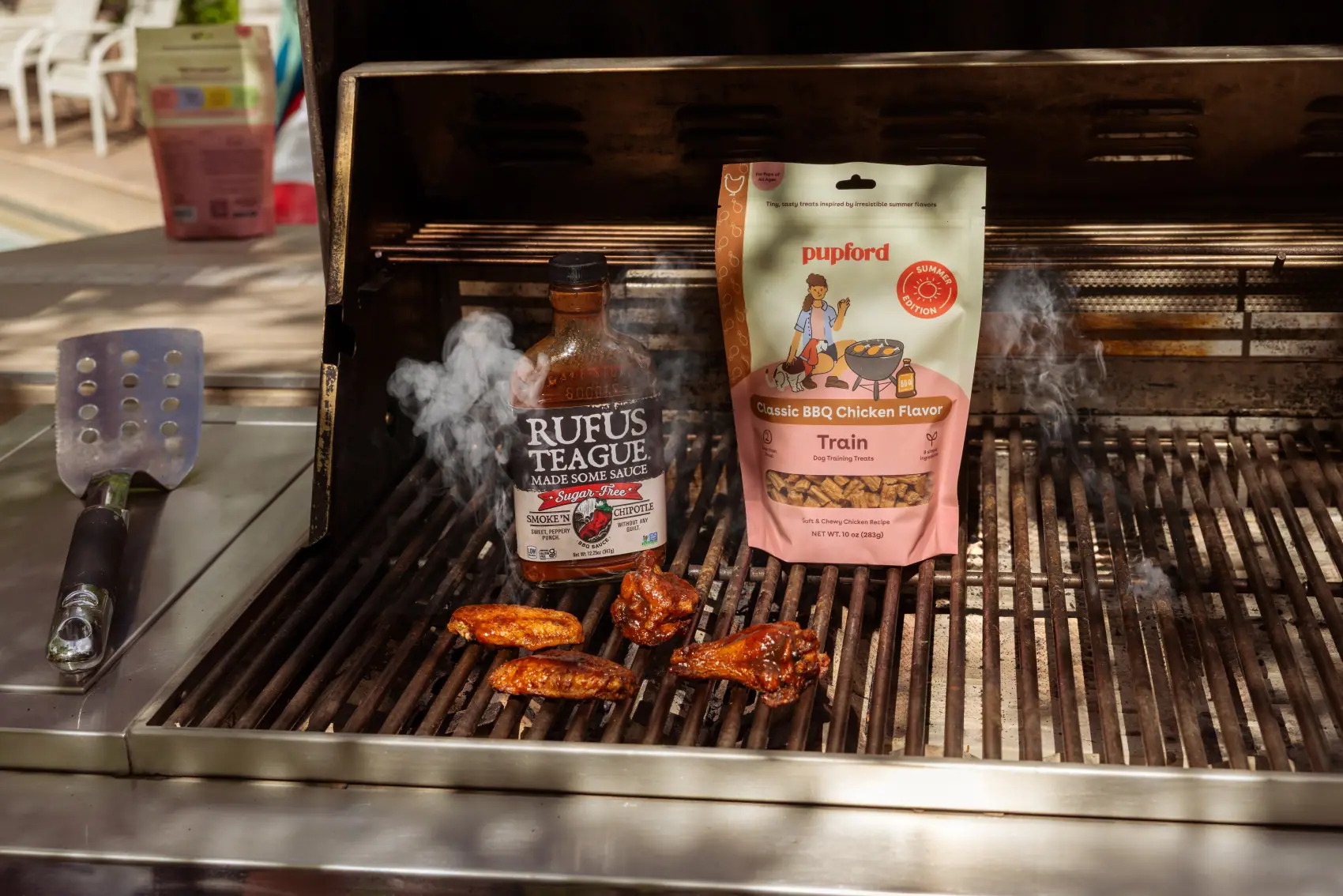Pupford Train BBQ chicken bag standing on a smoking grill beside barbecue sauce
