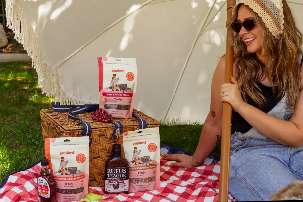 Woman on a gingham picnic blanket surrounded by the Pupford range