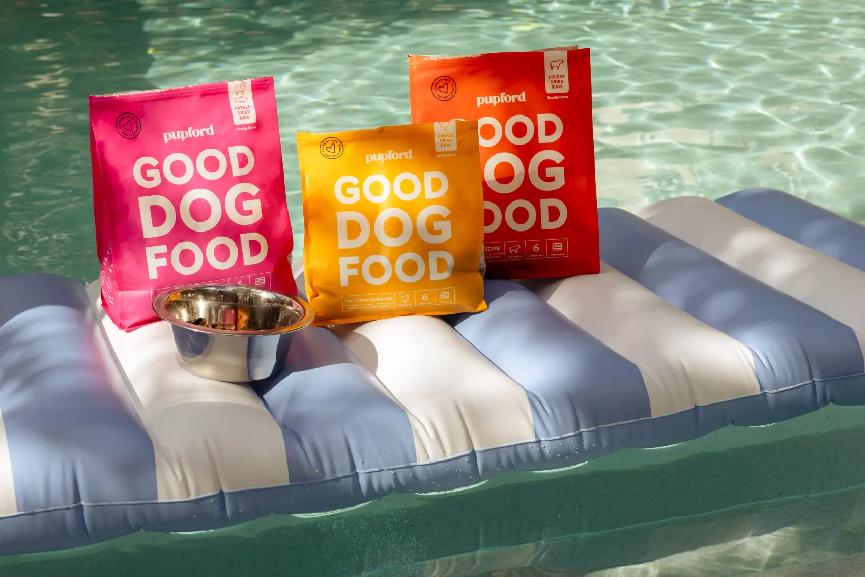 Three Good Dog Food bags arranged on a striped pool float